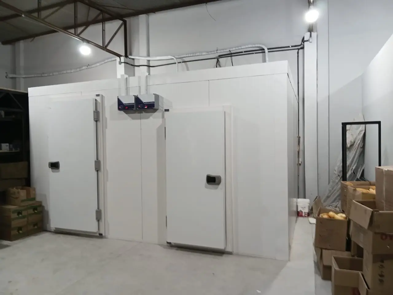Duas câmaras frias geminadas em painel isotérmico, com portas frigoríficas e evaporadores
