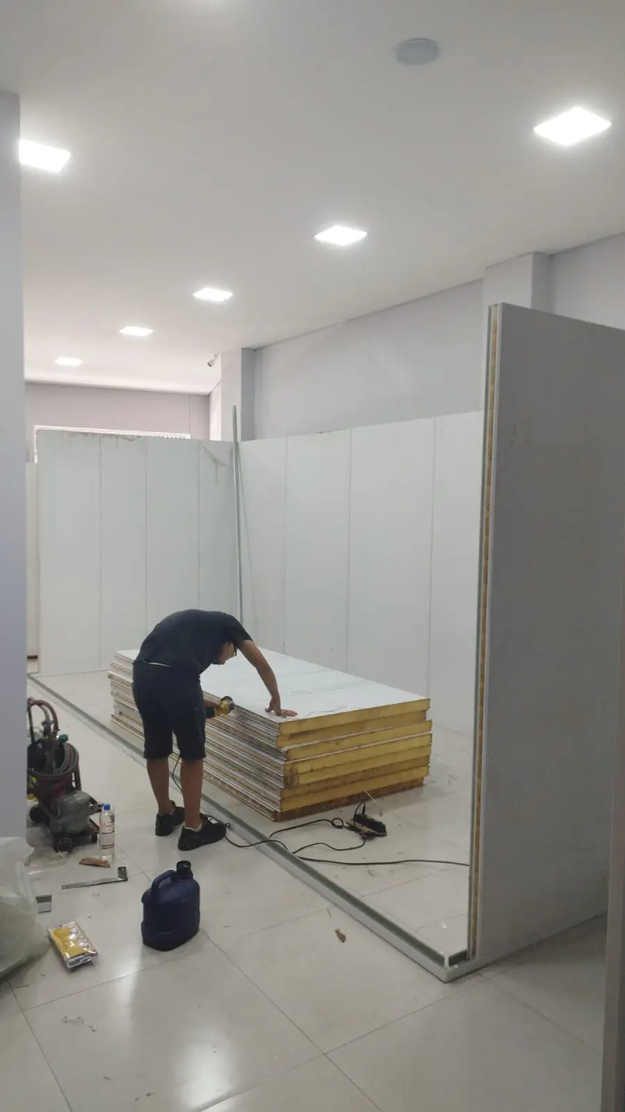 Técnico da Refrigóis montando painéis isotérmicos de câmara fria dentro de uma loja