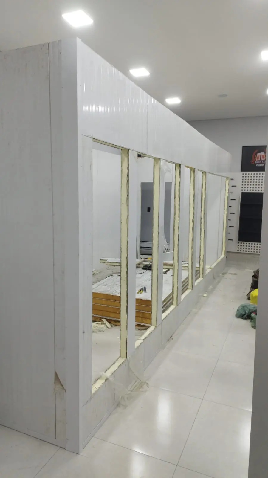 Estrutura de câmara fria em painel isotérmico com vãos recortados para portas de vidro